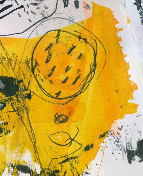 Abstract mixed-media artwork featuring a yellow and orange paint splash background with a black sketchy drawing of a circle with marks inside, resembling a stylized sun or face.