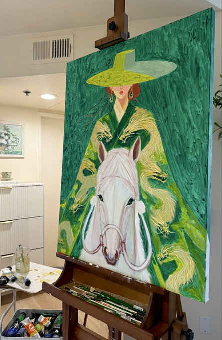 A painting on an easel depicting a white horse with a woman wearing a large yellow hat in the background, rendered in greens and yellows.
