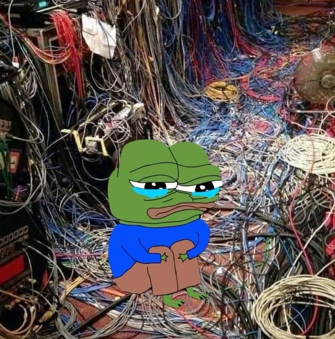 A Sad Pepe meme character (a green frog with tears, wearing a blue shirt) superimposed over a chaotic background of tangled electrical wires and cables.
