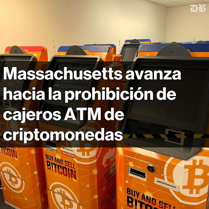 Several orange Bitcoin ATMs lined up in a row, displaying "BUY AND SELL BITCOIN" on their fronts, with Spanish text overlay reading "Massachusetts avanza hacia la prohibición de cajeros ATM de criptomonedas" (Massachusetts moves toward banning cryptocurrency ATM machines), illustrating the subject of the post about the state's legislative push to prohibit these machines amid rising fraud complaints.