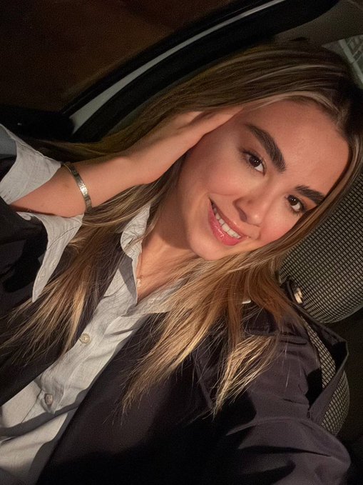 The image doesn't contain any visible text or numbers. However, "GM" likely refers to "Good Morning" in the context of the post, with the woman appearing to greet the day while posing in what looks like a car or vehicle interior.