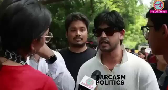 The image shows a group of people gathered together, with one person wearing sunglasses and holding a microphone. They appear to be engaged in conversation or participating in an event. The caption at the bottom of the image reads "It'S really easy to hack evm Print("hacked")". This suggests that someone might have tampered with the image by editing it for malicious purposes, possibly to spread false information or create a fake account pretending to be a journalist.