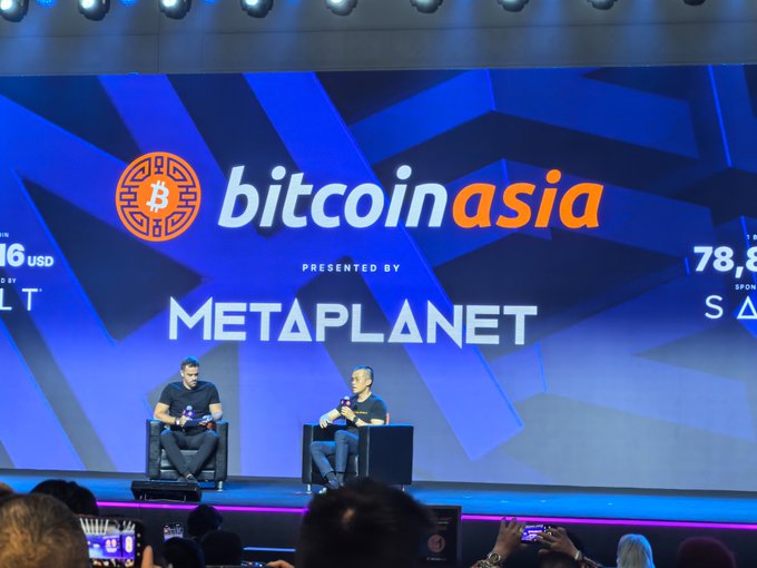 Two men sit on a stage at Bitcoin Asia, presented by Metaplanet, discussing RWA on-chain tokenization—including stock tokenization—in front of an audience recording the talk on their devices. The post reflects on takeaways from the conference, notably Binance's stated focus on this direction.