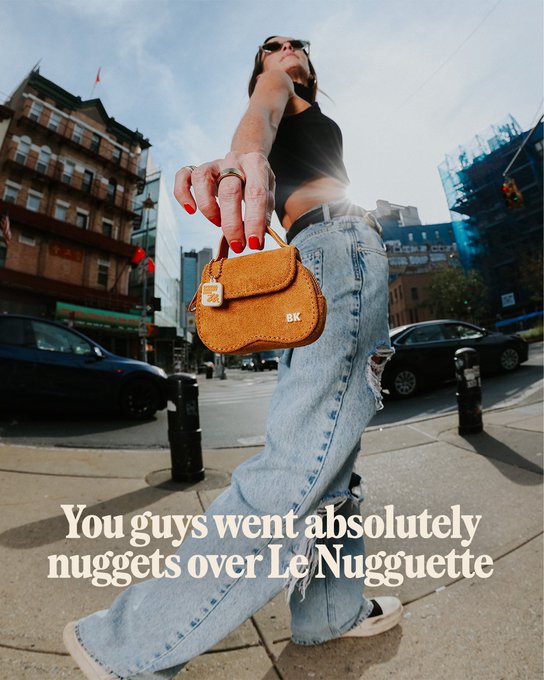 A woman holds up an orange fuzzy handbag shaped like a chicken nugget, with "BK" embroidered on the front, while standing on a city street in baggy jeans. The caption reads, "You guys went absolutely nuggets over Le Nugguette," tying into the post's promotion of limited drops of the playful nugget-shaped bag.