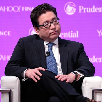 The image shows a man wearing glasses sitting in a chair while talking at a conference or event. The background has a purple wall with logos of Yahoo!, Prudential, Microsoft, and others. A microphone can be seen in front of him. In the foreground, there is text that reads "bitmine bought", possibly indicating an investment opportunity related to cryptocurrency mining. The post also mentions the value of the Bitcoins being exchanged, which might have relevance to the context or discussion being presented by the speaker at this event.