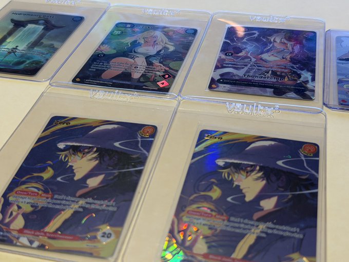 A collection of trading cards (including ones with Thai text and anime-style artwork) displayed in clear protective sleeves, with visible cards featuring characters and a label reading 'VSLIP'.