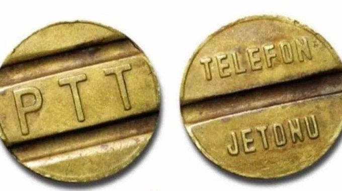 Two sides of a brass PTT telephone token (Telefon Jetonu) are shown, common tokens used in Turkish payphones.