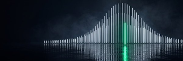 A nighttime view of an illuminated bridge over water with a green light in the center.