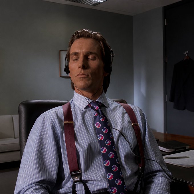 The image shows a man sitting at an office desk, wearing headphones and looking relaxed with his eyes closed. The photo has been edited to emphasize the importance of the content displayed in the caption below the image.