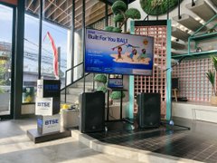 An indoor BTRS Bitcoin ATM kiosk featuring a large digital display screen and two ATM machines in a commercial setting.
