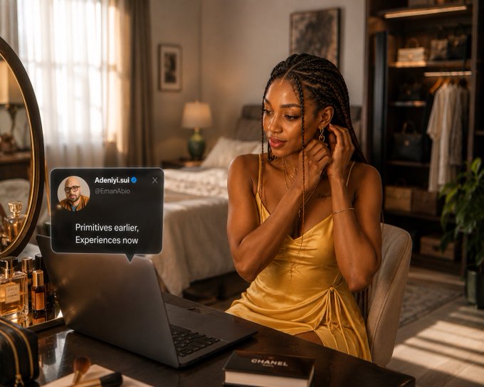 A woman in a yellow satin dress sits in an elegant bedroom working on a laptop, with a social media post overlay reading '@Adeniyi.sui' and '@EmanAbio' saying 'Primitives earlier, Experiences now.'