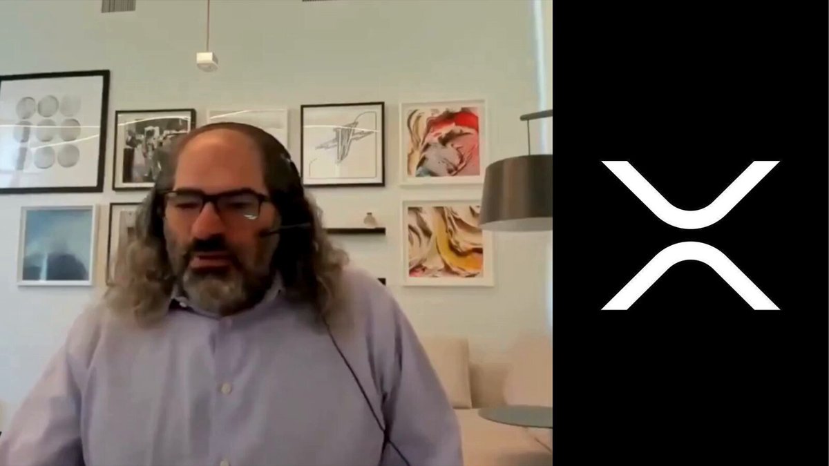 The image features a man wearing glasses, sitting at a desk with headphones on his head. He appears to be engaged in an online meeting or video call while wearing a headset. The background of the image shows several framed pictures hanging on the wall behind him. There is also a logo for Ripple Inc., which is white and black in color. The post includes text that reads, "THIS IS BIG: $XRP escrow could be fully exhausted sooner than most people expect. David Schwartz: 
"demand will decide."".