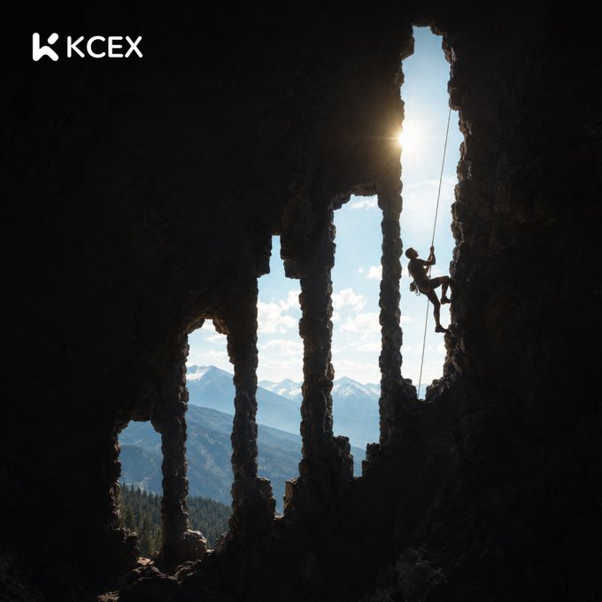 KCEX cryptocurrency exchange promotional image showing a climber silhouetted against sunlight in a rocky cave structure with mountains visible in the background.