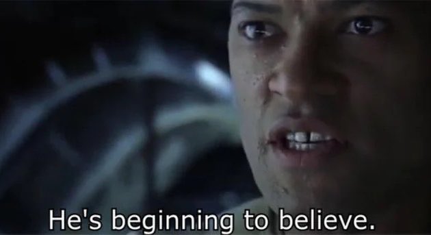 A close-up movie still of a man looking emotional and tearful, with the subtitle text 'He's beginning to believe.'