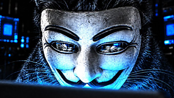 A close-up of a person wearing the iconic Guy Fawkes mask from 'V for Vendetta,' illuminated by blue light from a computer screen reflecting in the mask's eyes.