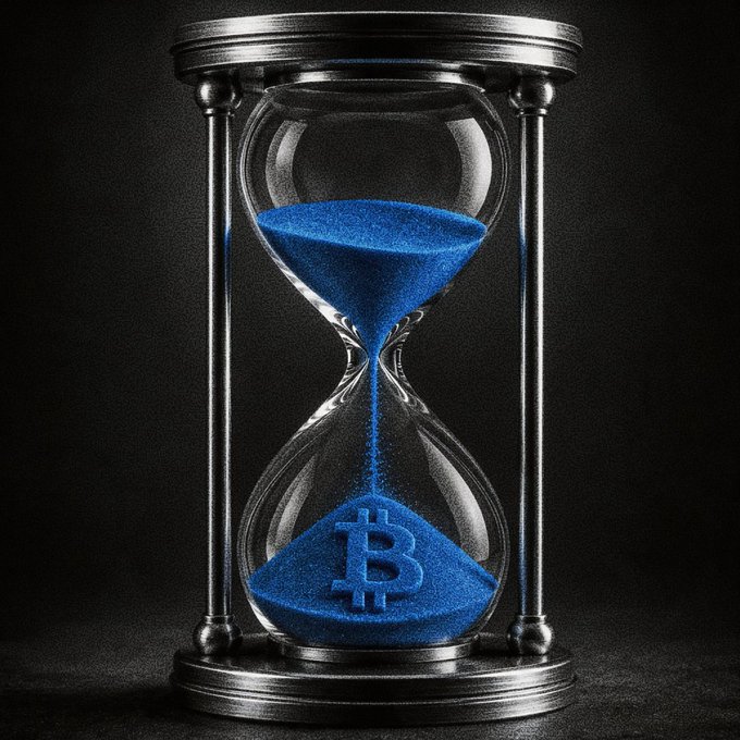 An hourglass filled with blue sand features the Bitcoin "₿" symbol in the bottom chamber, symbolizing the passage of time and anticipation in the crypto market. The imagery pairs with the post's Monday greeting, evoking patience through market "headwinds" while referencing Huobi's USDT earnings opportunity.