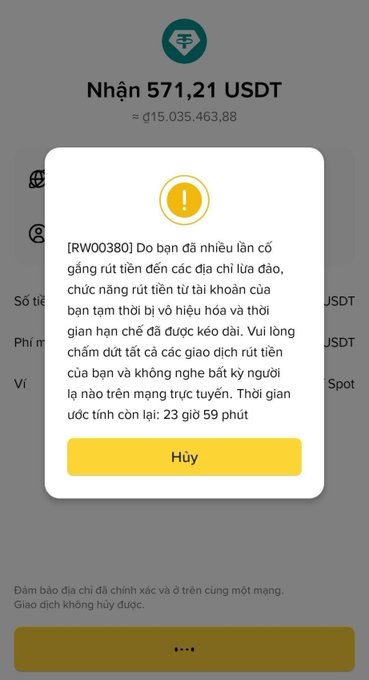 A Vietnamese-language cryptocurrency wallet interface showing a transaction warning popup for receiving 571.21 USDT (approximately 115,035,463.88), with a security alert [RW00380] warning about multiple attempts to withdraw funds to scam addresses and a countdown timer showing 23 hours 59 minutes remaining.