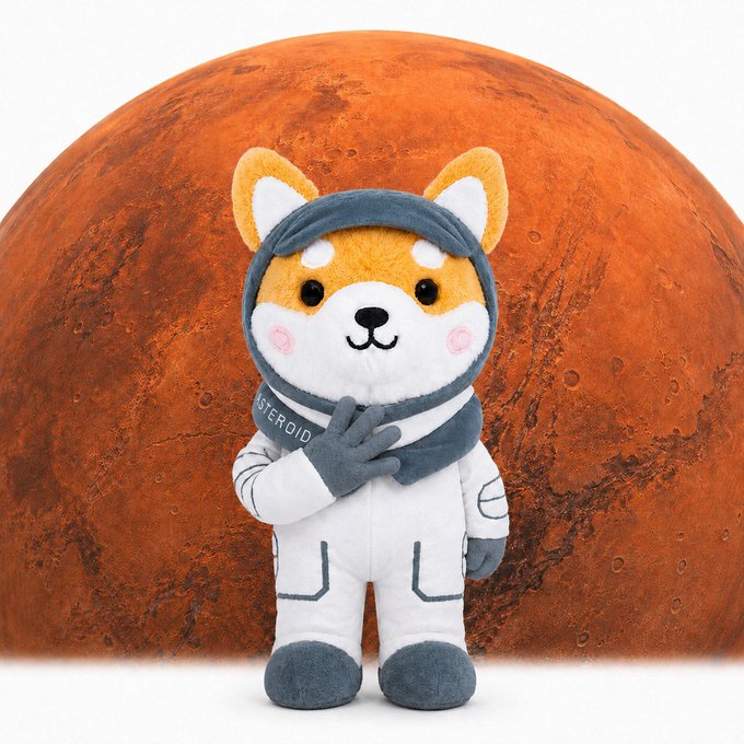 A plush toy of a Shiba Inu dog dressed in a grey and white astronaut suit, posed in front of a large image of the planet Mars.