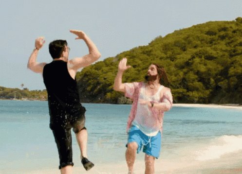 iced tea and a glass of water on the beach, with two men engaged in a playful dance.