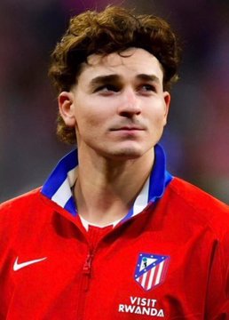 A young male soccer/football player wearing a red Atlético Madrid jersey with 'Visit Rwanda' sponsorship and the Nike logo.