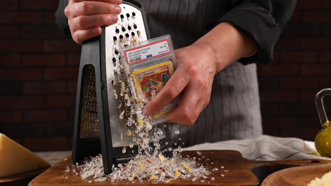A chef grating a Pokémon trading card with a box grater, scattering colorful bits onto a wooden board—a visual pun on the "cards graded" joke.