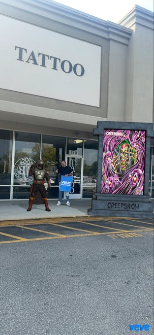 An outdoor photograph shows a 'TATTOO' shop with a 'CREEPSHOW' poster on the right; a person in a warrior costume stands on the sidewalk with another person taking a photo.