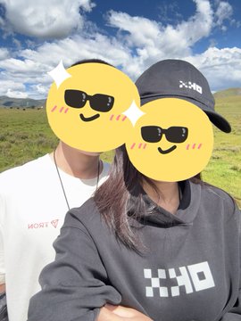 Two people take a selfie outdoors on a grassy hill under a cloudy blue sky; their faces are covered by sunglasses emojis, and one wears a black hoodie with a white checkered 'CRYO' logo and a 'DC' cap.