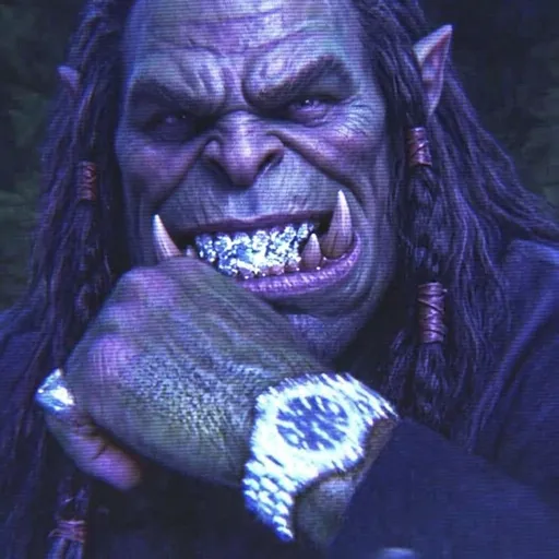 A close-up of an orc-like creature with pointed ears, long dark hair, and prominent tusks, grinning menacingly while wearing a large jeweled ring on its finger.