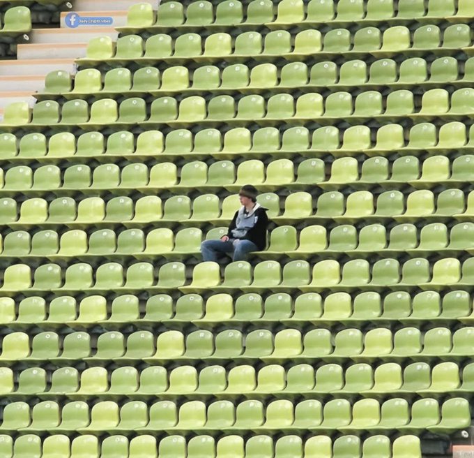 The image shows a person sitting alone in an empty stadium, surrounded by rows of green seats that appear to be empty as well. The person seems to be wearing a black jacket and hat, possibly enjoying some solitude or taking a break from their activities. The post about being bullish right now suggests that the person might be experiencing a sense of excitement or anticipation related to sports events, such as a game or match. It could also indicate that they are waiting for an important event or outcome in which they have invested time and effort.