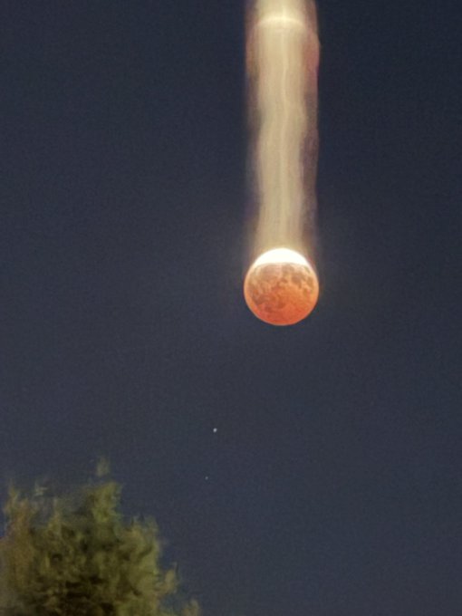 A blood-red lunar eclipse, with a glowing trail extending upward from the moon against the night sky, visually represents the Bitcoin "bull run" referenced in the post, with the rising fiery moon symbolizing the anticipated upward surge in BTC price.