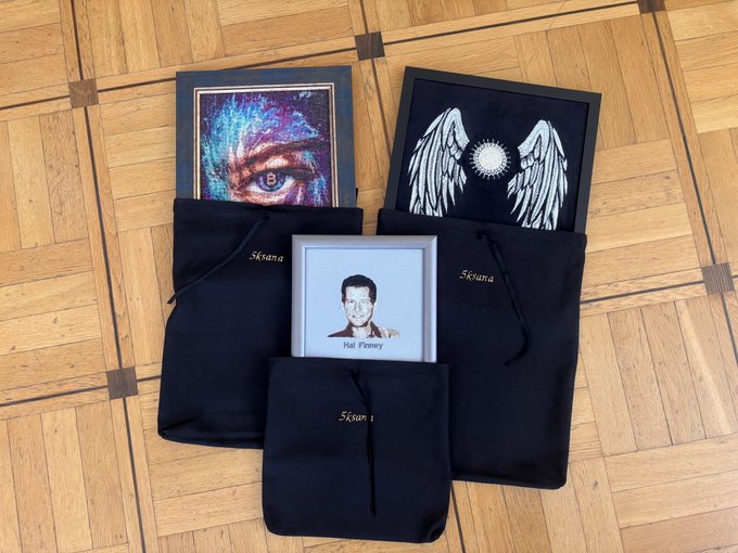 The image shows a collection of paintings that are packed into black bags or cases. There are four distinct paintings displayed in the scene, each with unique characteristics. The first painting features an eye and wing design, while the second one has a man's face on it. The third painting is a portrait of a person, and the fourth painting showcases a bird. These paintings are being packed for travel or storage purposes, possibly as part of a collection or for selling at an art gallery.