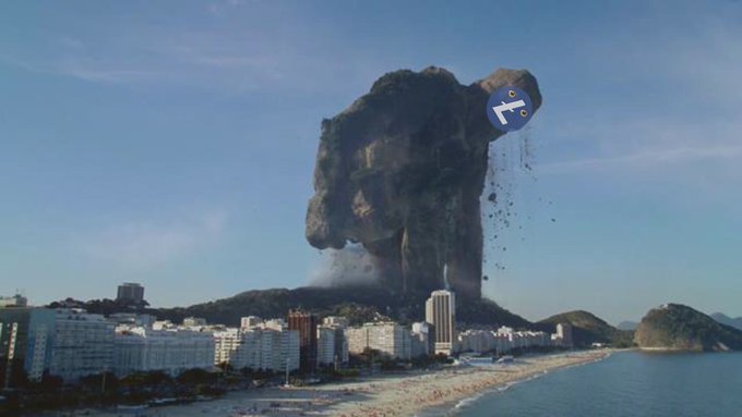 The image features a large rock formation that has been transformed into an advertisement for Litecoin. The rock formation appears to be a mountain with a face carved into its surface, and there are buildings located at the base of this unique structure. A blue sign is placed on top of the rock formation, which reads "Litecoin, the sleeping giant awakens". This creative use of advertising has caught the attention of viewers who can now appreciate the juxtaposition between nature's landscape and the digital currency being promoted.

The image also includes a cityscape in the background, providing context to the advertisement's location. The combination of natural elements like the rock formation and man-made structures such as buildings creates an interesting contrast that highlights the advertisement's message.