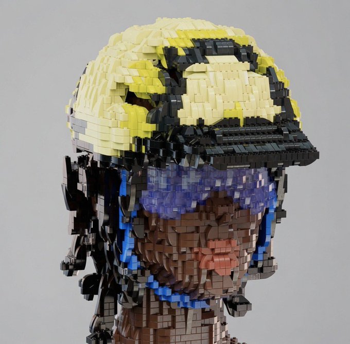 A detailed LEGO sculpture of a human head and shoulders, featuring intricate pixelated details in the hair, face, and eyes made from various colored bricks.