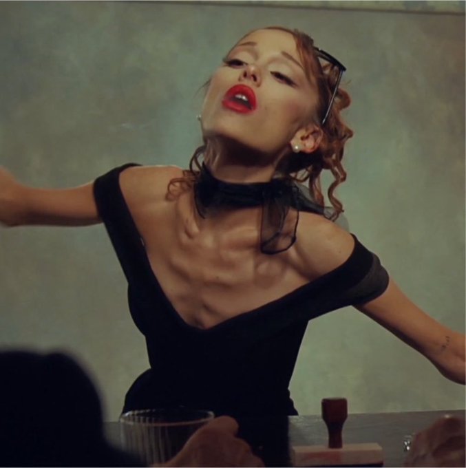 A woman in a black dress and red lipstick throws her head back dramatically while standing behind a counter. The image humorously exaggerates her yearning expression to convey the desperate, hungry waiting of a crypto trader anticipating a six-figure airdrop amid Bitcoin's potential drop below $60K.