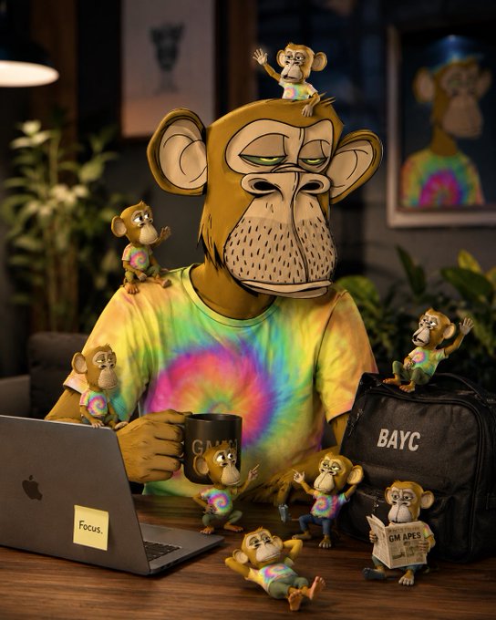 A 3D-rendered Bored Ape Yacht Club (BAYC) NFT character wearing a tie-dye shirt, sitting at a desk with a laptop labeled 'Focus,' holding a GM mug, with smaller monkey figures around and a BAYC bag.