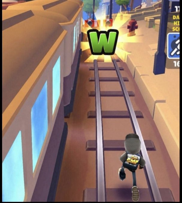 A screenshot from the mobile game Subway Surfers showing a character running on train tracks, holding up a glowing green 'W' trophy symbol.