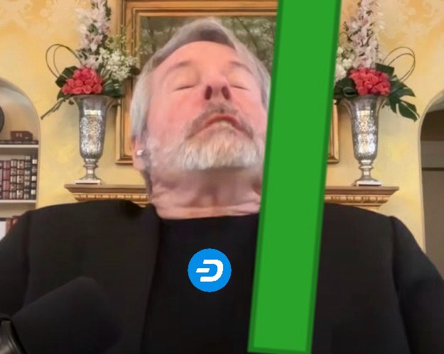 A close-up shot of a man with grey hair and beard in a black shirt, eyes closed, with a green graphical bar and a blue 'D' logo overlaid on the image.