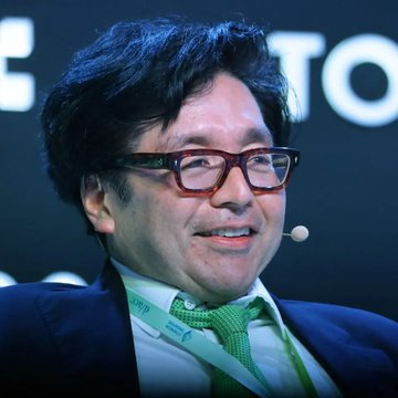 Tom Lee, wearing a headset microphone and glasses with a green tie, is pictured here—likely during a speaking engagement—relating to the post about Bitmine's $81 million Ethereum purchase, his largest weekly ETH accumulation since early July, occurring amid a 30% weekly surge in ETH's price.