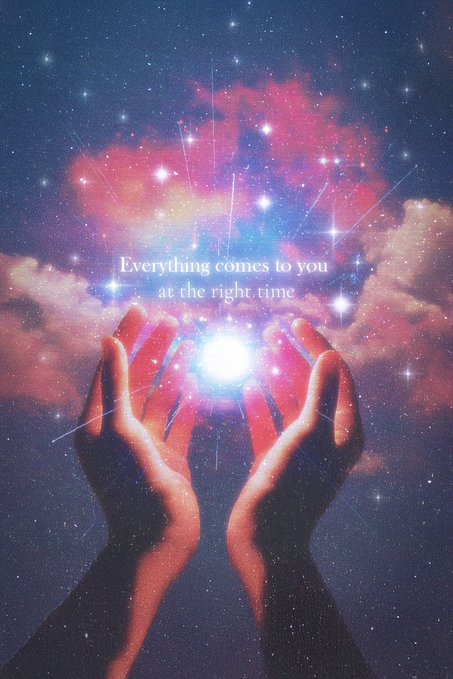 A surreal cosmic artwork showing two hands cradling a glowing orb of light against a starry pink and blue nebula, with the text 'Everything comes to you at the right time.'