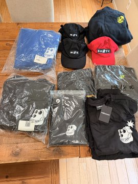 A collection of vintage-style hoodies and caps displayed on a wooden table, featuring brand names like "BAPE" and "BABY" on hats and skull logo apparel packaged in plastic bags, suggesting rare streetwear finds from an attic collection. The post's mention of "og pieces" and "grails" aligns with the displayed items, indicating sought-after original streetwear items available for sale.