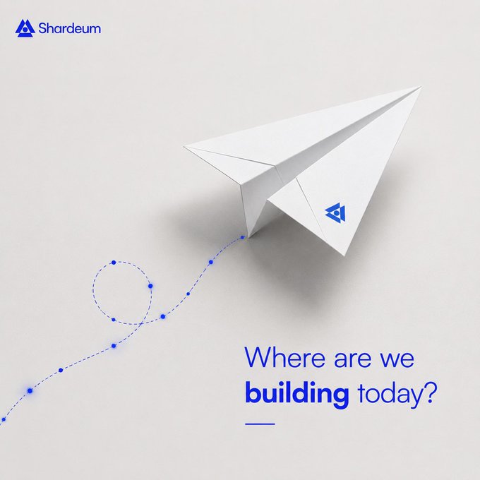 The image shows a white paper airplane with the Shardeum logo, accompanied by the text "Where are we building today?" and a dotted trail path, inviting community members to share their cities as part of a "GM" (good morning) social post to map the global Shardeum community.