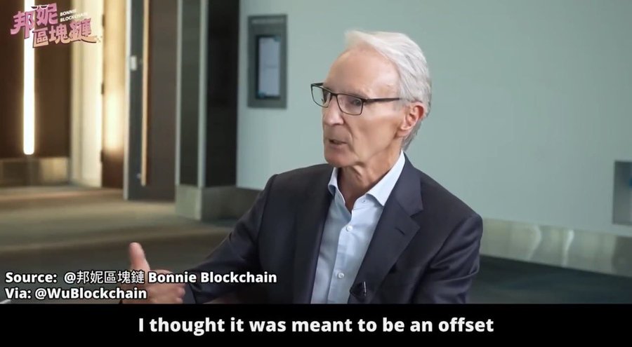 The image shows an older man with white hair and glasses, wearing a dark suit and light blue shirt, speaking during an interview in what appears to be an office hallway, with subtitles reading "I thought it was meant to be an offset." The source is credited to Bonnie Blockchain via WuBlockchain, and the clip relates to David Tait's comments on Bitcoin's volatility as a non-safe-haven asset, aligning with the post's discussion of World Gold Council skepticism toward BTC.