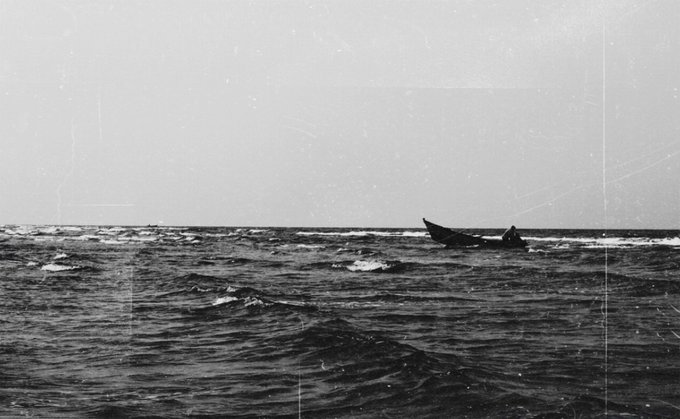 The image shows an ocean scene with a boat floating in the water, surrounded by waves. The photo has been edited into black and white, giving it a vintage appearance. In the bottom right corner of the image, there's text that reads "Morning friends Happy weekend Grateful to share that an edition of 'The Hidden Tide' has found a new home Thank you my amazing friend @GarbinJaime for your support and trust in my work It truly means a lot  3xtz On". The post is about sharing the edited image with others, and it seems like someone has posted this picture to share their experience of sailing on the ocean.