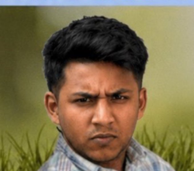 A portrait shows a young man with dark hair looking seriously at the camera, wearing a plaid shirt against a blurred green background.
