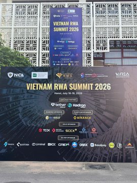 A billboard and large banner promote the 'VIETNAM RWA SUMMIT 2026' on July 15–16, 2026, featuring logos of sponsors like NCA, KW&S, VISA, TradingView, Indodax, and Binance.