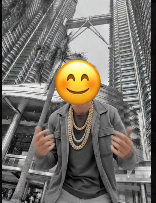 Good morning—get money, rise, and shine! 😄 A person in chains and a gray jacket poses confidently in front of the Petronas Twin Towers, reinforcing the post’s message of ambition and success.