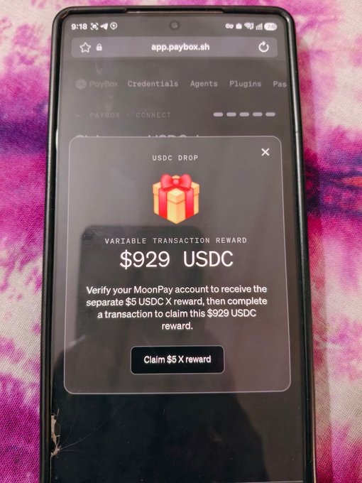 A smartphone displays the app.paybox.sh website showing a "USDC DROP" Mystery Box offering a variable transaction reward of $929 USDC, with instructions to verify a MoonPay account and claim a separate $5 USDC X reward—illustrating the MoonPay Mystery Box reward process described in the post.