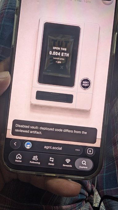 A smartphone displays a page on agnt.social showing a 'Disabled vault: deployed code differs from the reviewed artifact' message, with a chip image reading 'OPEN THIS 0.004 ETH Launch price'.