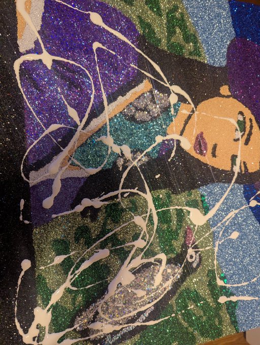 An abstract mixed-media artwork featuring glittery, textured patches of purple, green, blue, and orange overlaid with sweeping white drips and splatters.