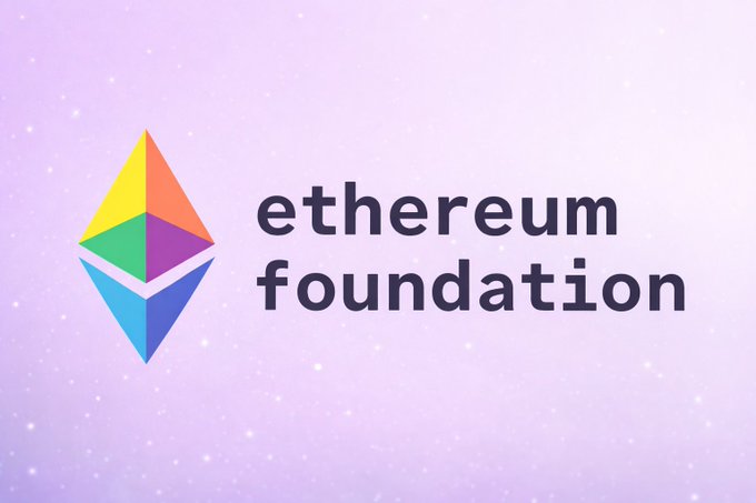 The image features a logo for an organization called the Ethereum Foundation, which is a non-profit dedicated to the development of blockchain technology. The logo consists of a colorful triangle with a rainbow inside, symbolizing the diversity and innovation associated with the Ethereum ecosystem. The text "Ethereum Foundation" is written below the logo in black letters.

The image also contains some text that reads: "JUST IN: Ethereum Foundation confirms internal restructuring and staff departures as it streamlines protocol R&D and sharpens focus on Ethereum's long-term roadmap and core development priorities." This part of the image provides context about the organization's recent activities, such as reorganizing their operations to improve efficiency and focusing on key aspects of their work.